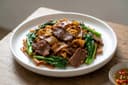 Gebratene breite Reisnudeln mit Rindfleisch